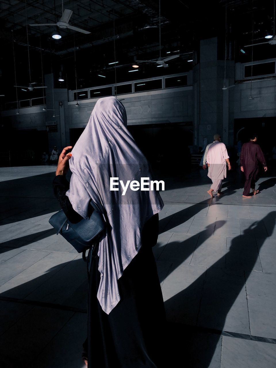 Rear view of a muslim women walking on footpath