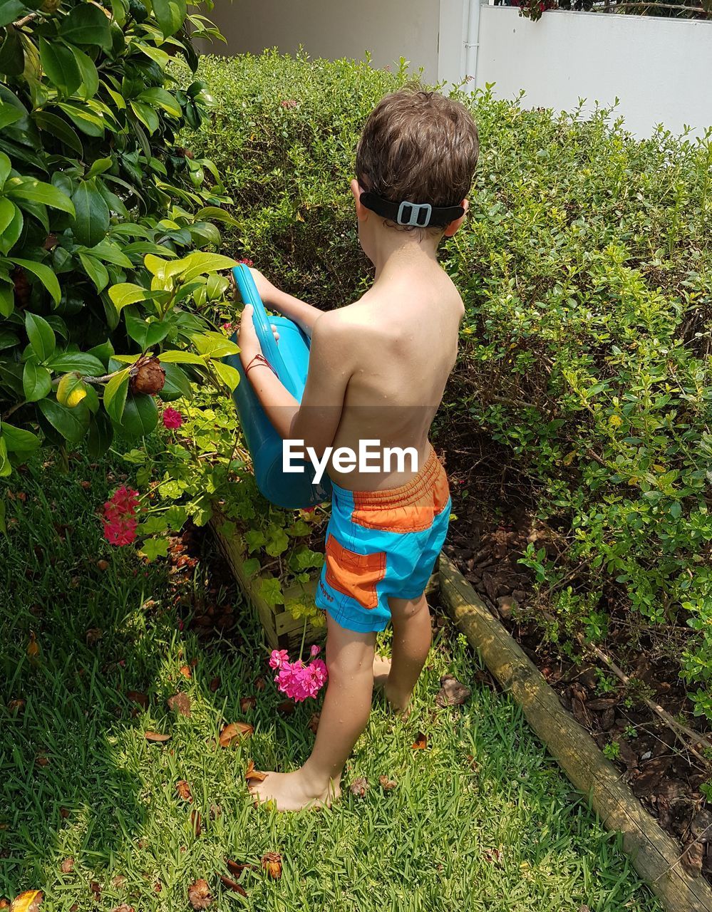 BOY PLAYING IN WATER AT YARD