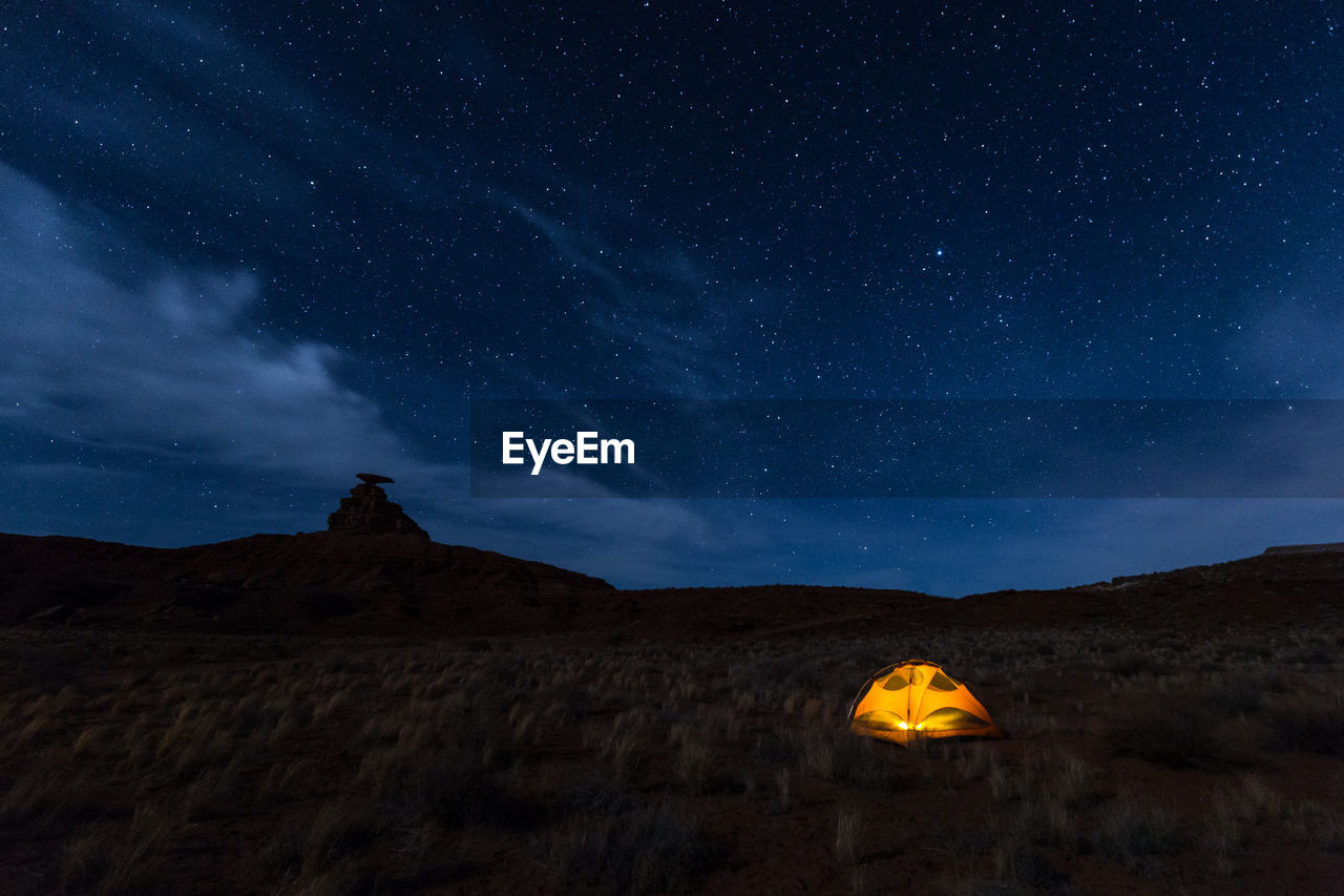 Scenic view of illuminated tent on field against sky at night