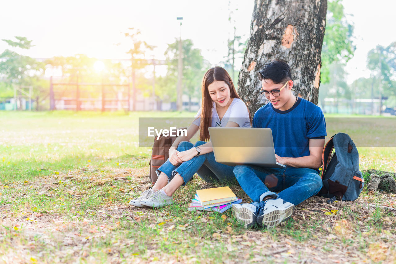 University students using laptop at park