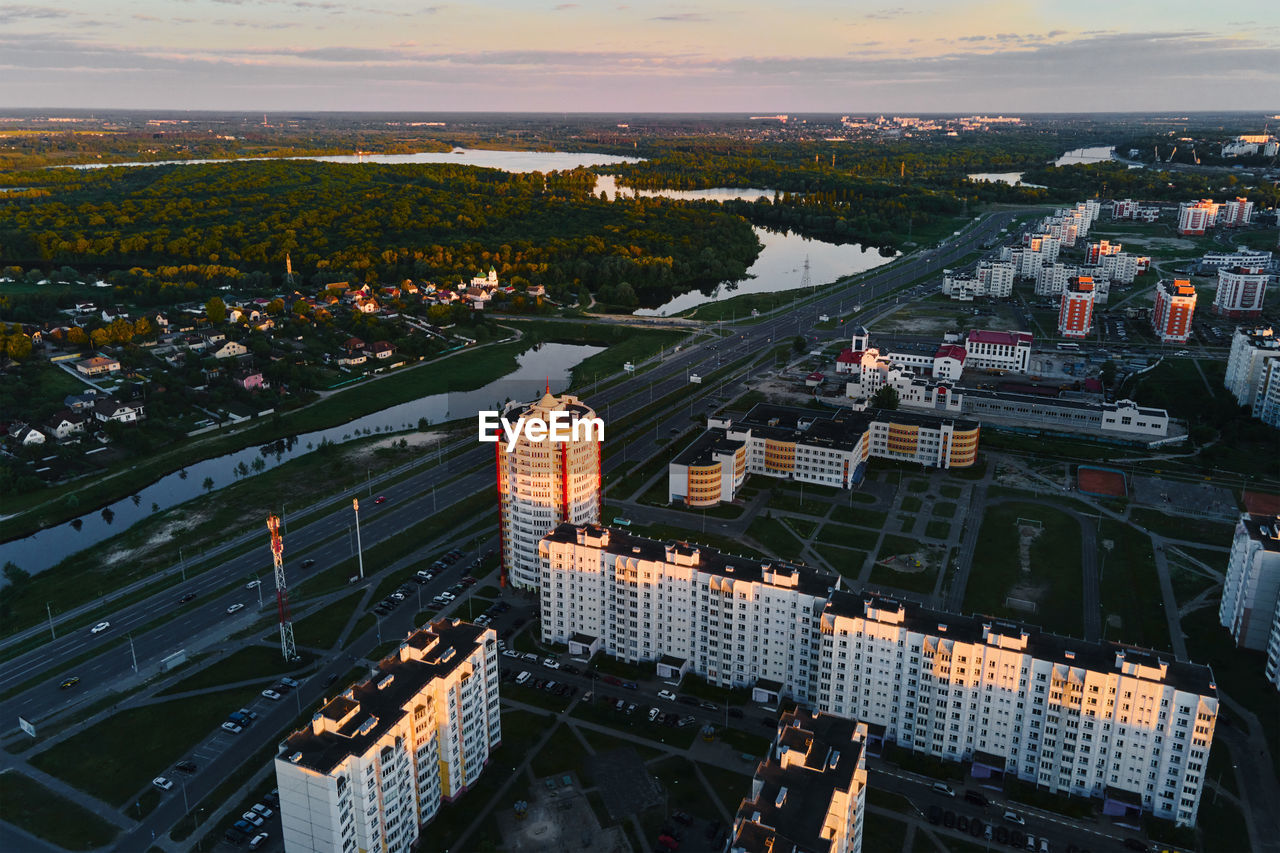 HIGH ANGLE VIEW OF TOWNSCAPE BY RIVER AGAINST BUILDINGS