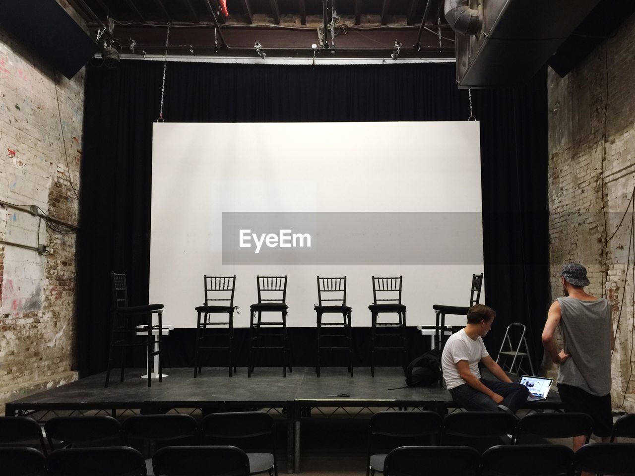 Men discussing on stage in theater