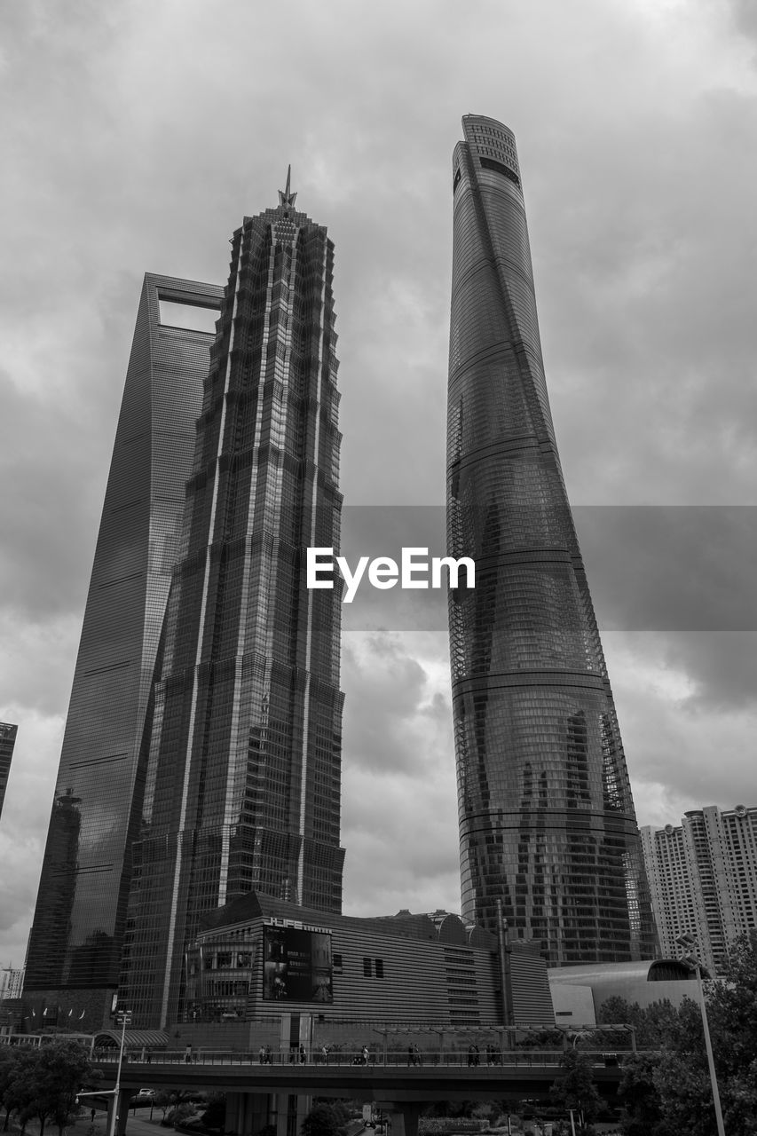 LOW ANGLE VIEW OF BUILDINGS IN CITY AGAINST CLOUDY SKY