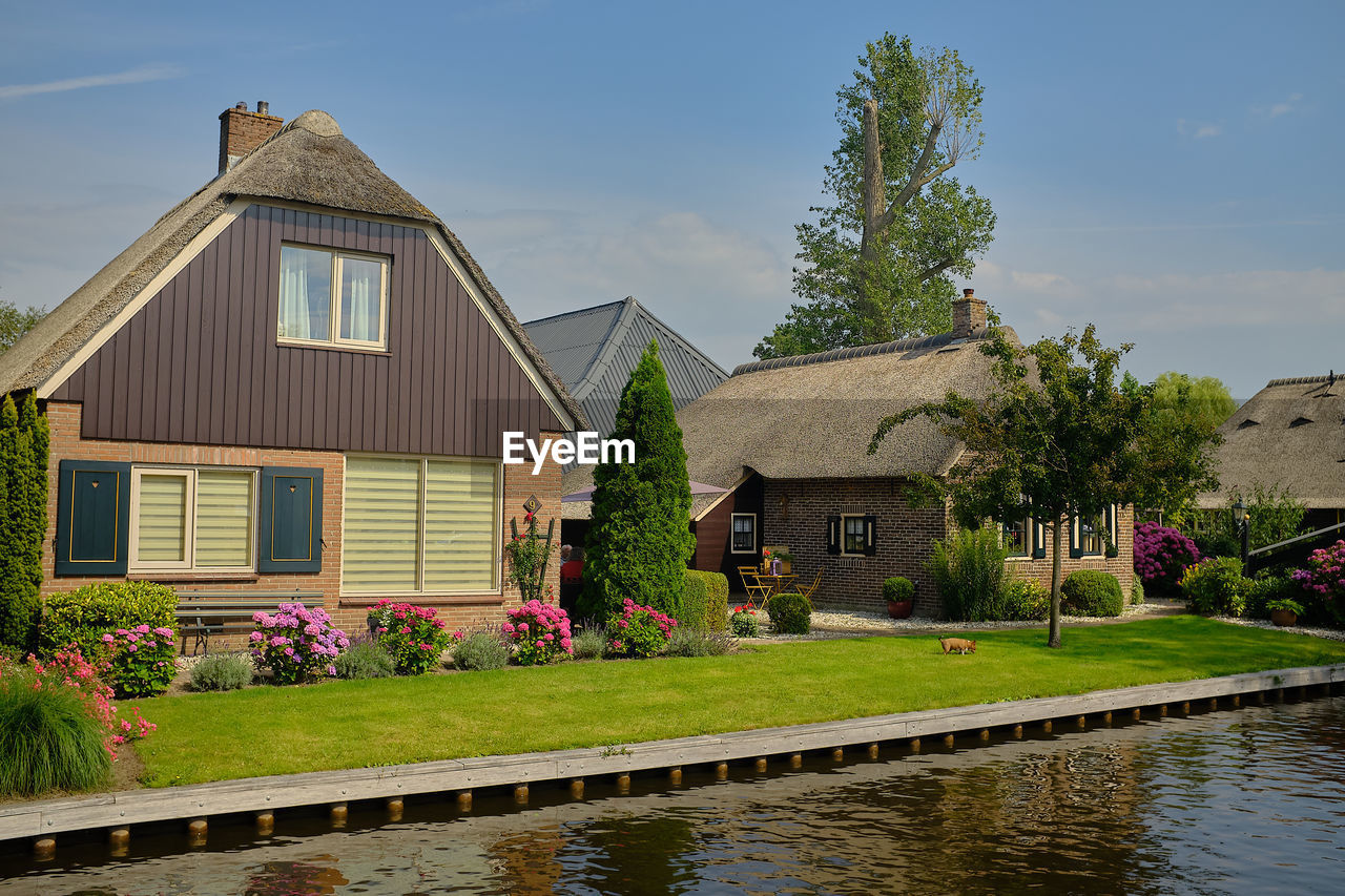 HOUSE BY LAKE AGAINST SKY