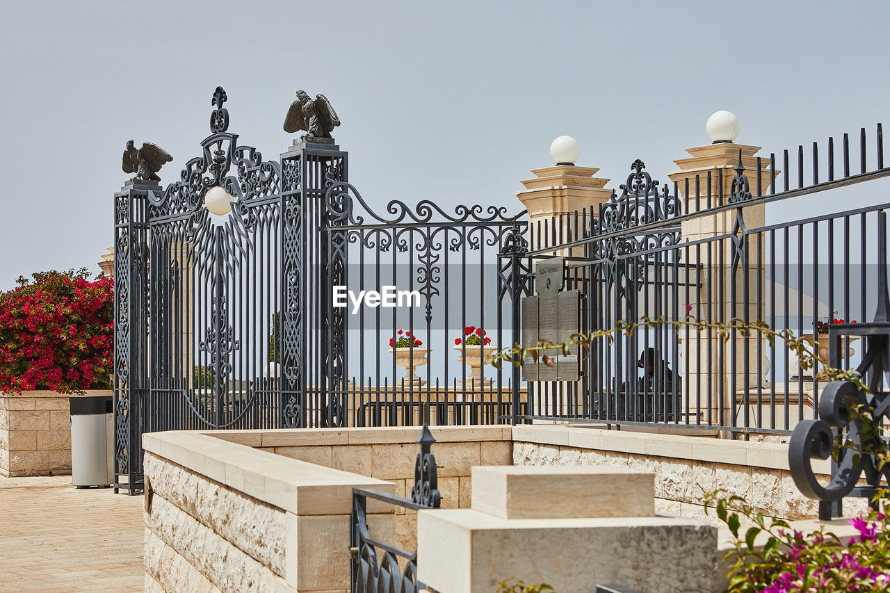 architecture, flower, nature, flowering plant, gate, railing, baluster, plant, built structure, sky, building exterior, fence, travel destinations, wrought iron, no people, outdoors, building, city, travel, day, iron, sunny, history, mansion, the past, tourism, residential district, clear sky
