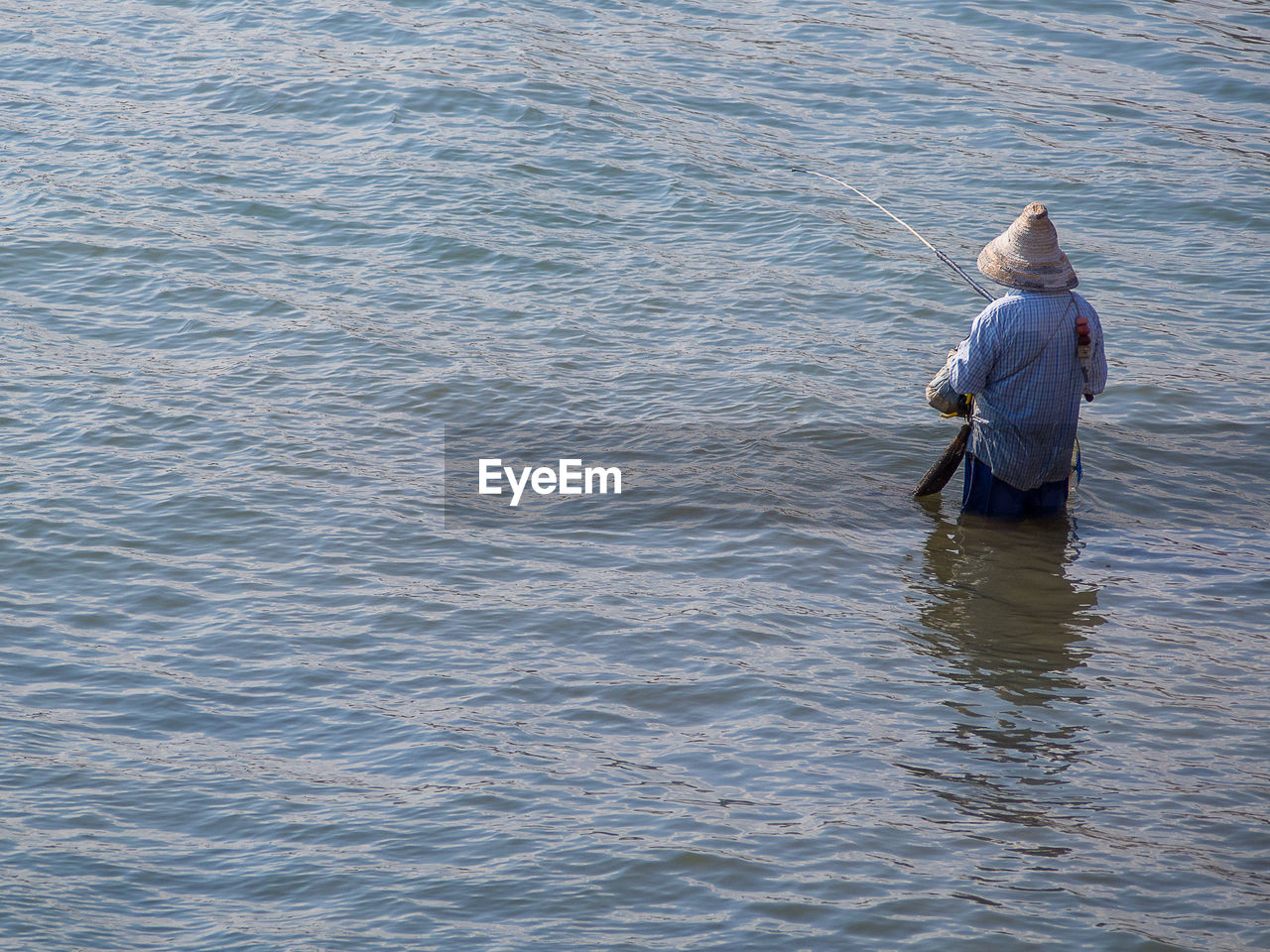 Rear view of man fishing in sea