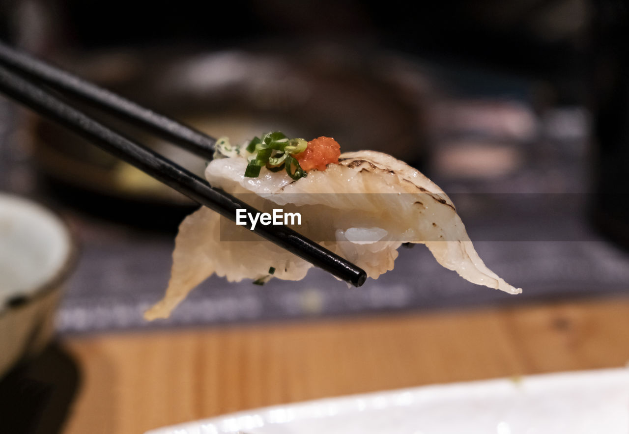 Close up of sashimi sushi with chopsticks and soy