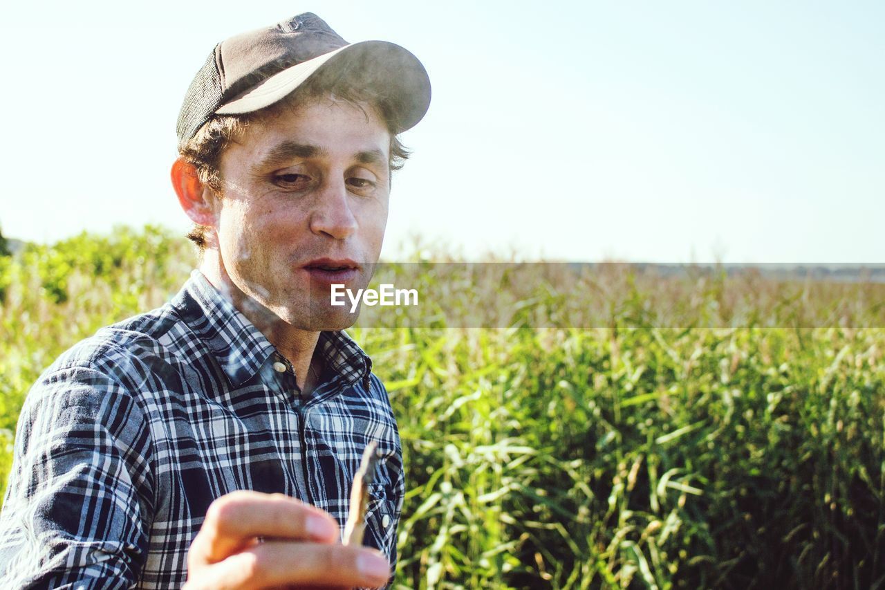 Man smoking marijuana joint on field