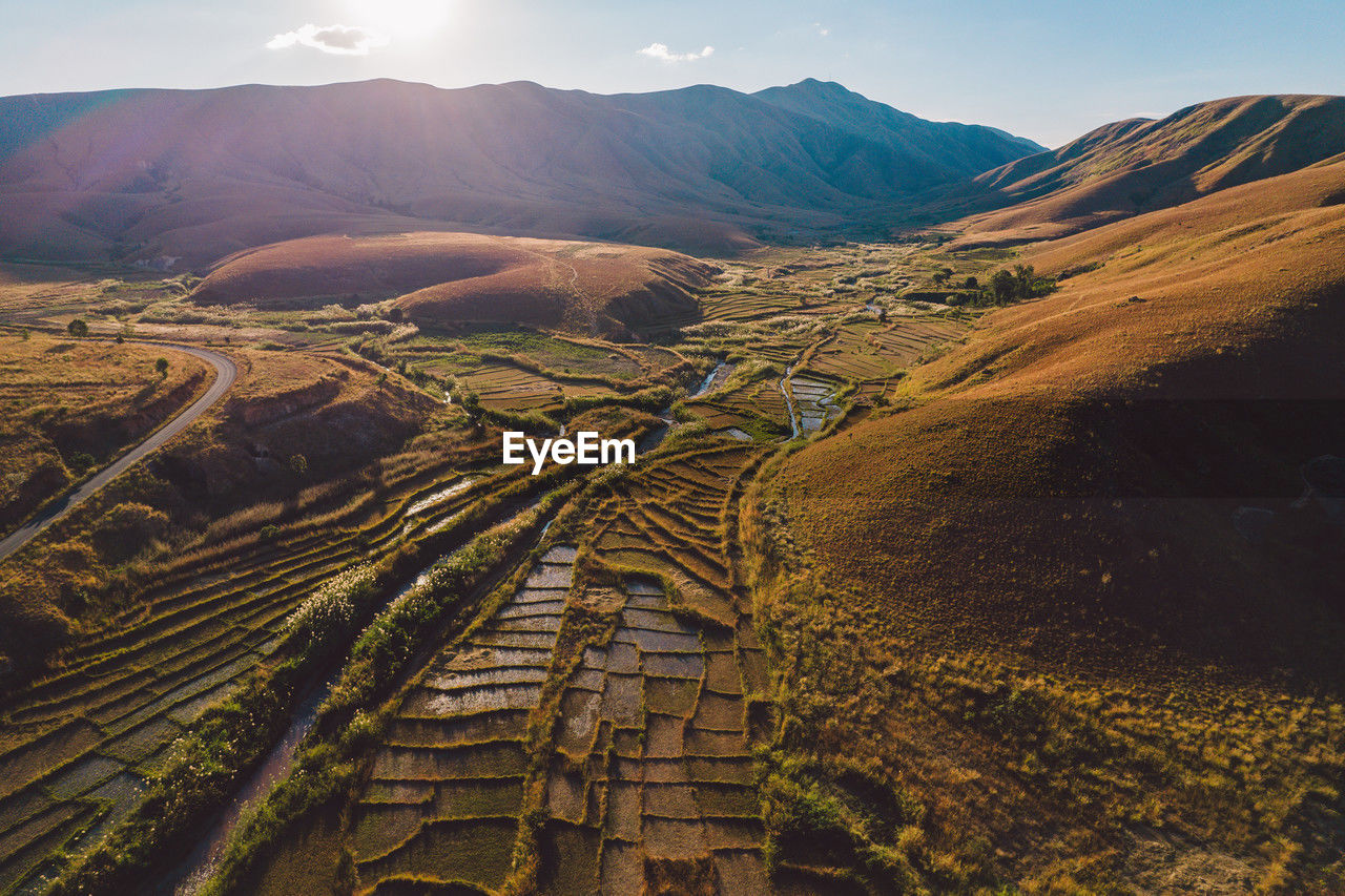 landscape, environment, scenics - nature, mountain, land, nature, sky, beauty in nature, rural scene, valley, agriculture, mountain range, travel, no people, aerial photography, sunlight, travel destinations, tranquility, outdoors, field, horizon, plateau, non-urban scene, plant, day, wilderness, tranquil scene, sun, cloud, rural area, farm, high angle view, plain, tourism, social issues, environmental conservation