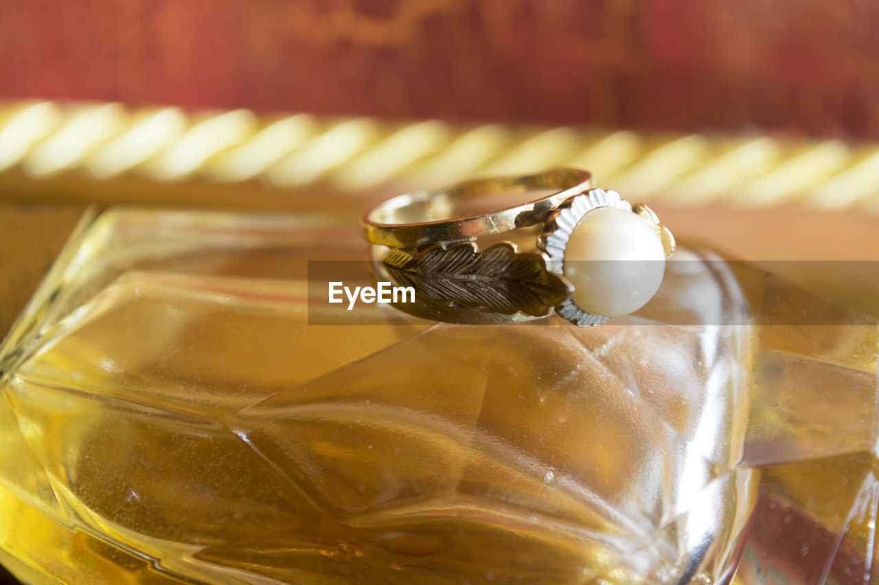 Close-up of pearl ring on perfume bottle