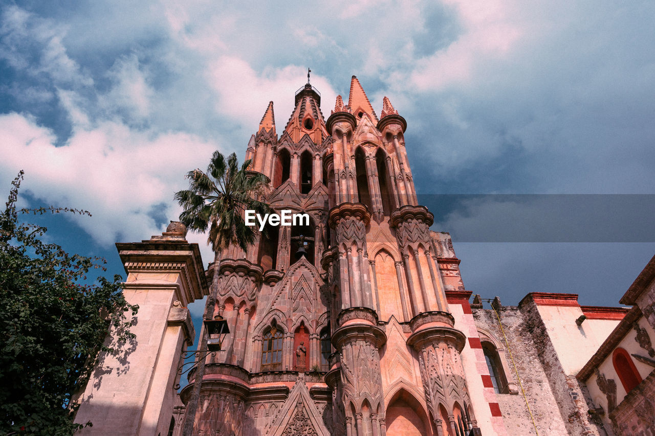 Low angle view of temple building against cloudy sky