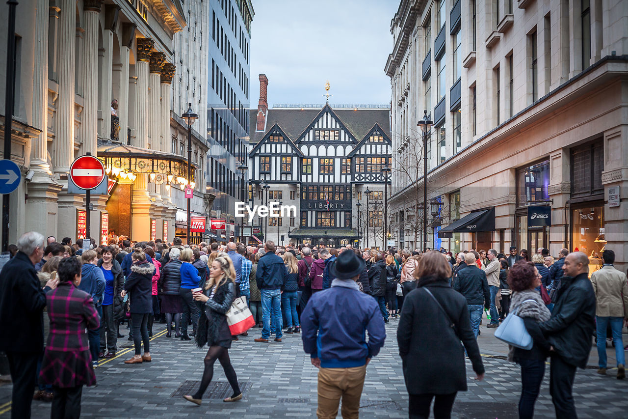 People on street amidst buildings in city