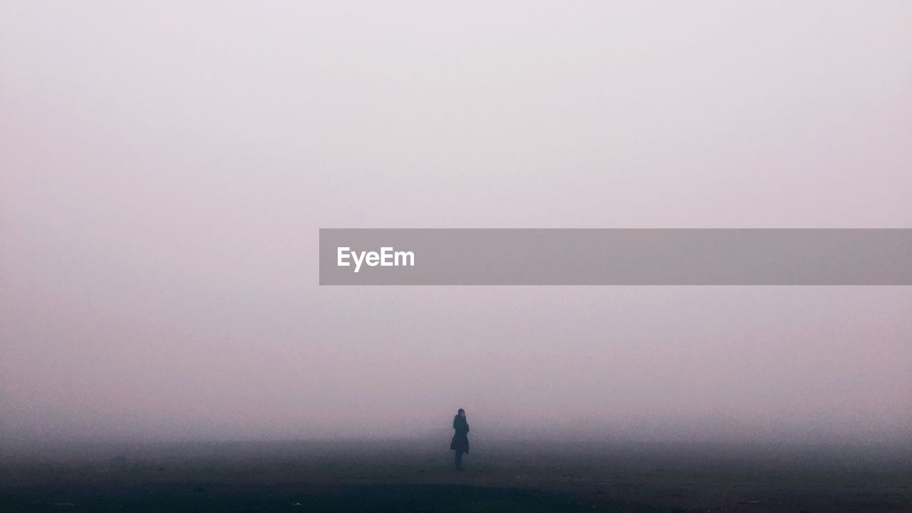 Rear view of man standing in foggy weather