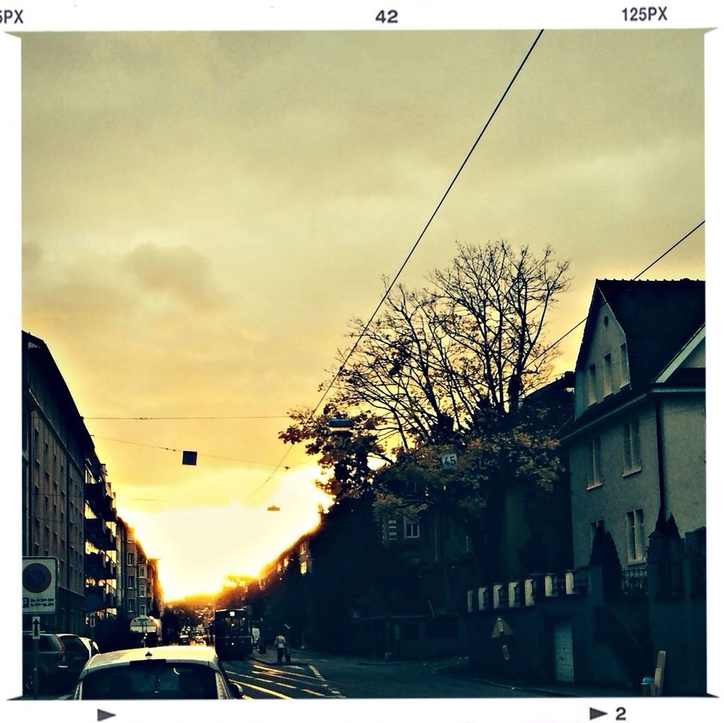 City street and buildings against sky at sunset