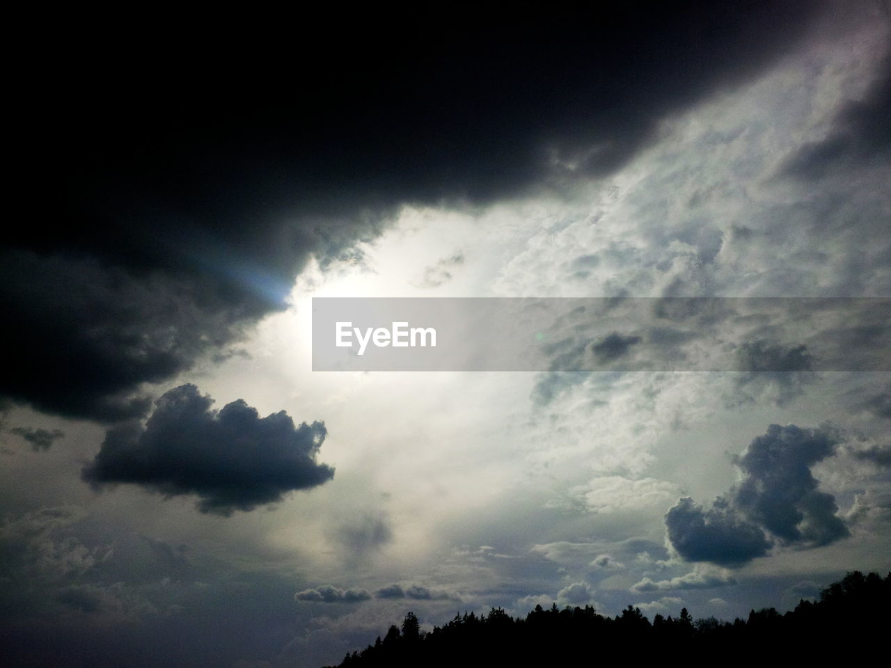 LOW ANGLE VIEW OF SKY WITH SILHOUETTE TREES AGAINST CLOUDY BACKGROUND