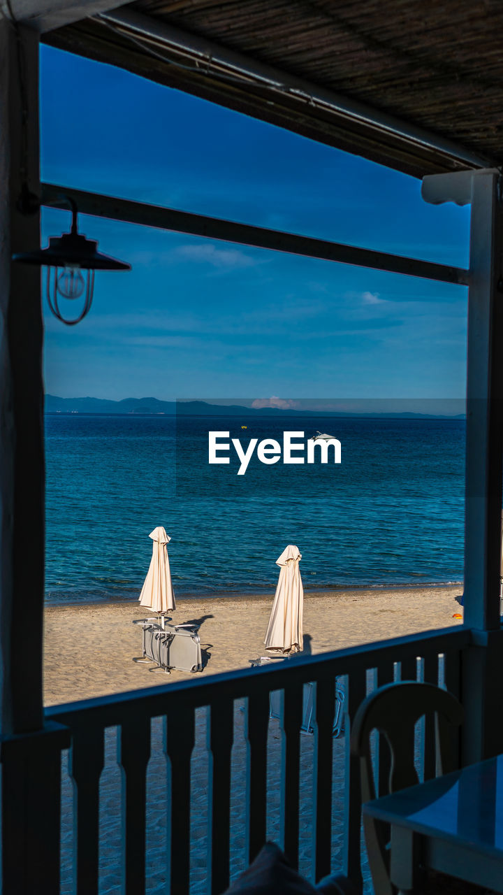 SCENIC VIEW OF SEA AGAINST BLUE SKY SEEN THROUGH BOAT