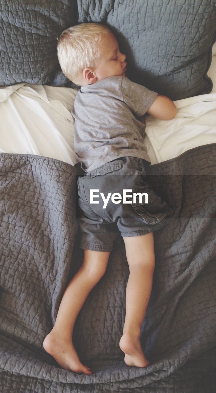 Directly above shot of boy sleeping on bed