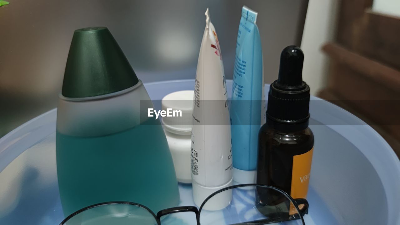 HIGH ANGLE VIEW OF BOTTLES AND PEN ON TABLE