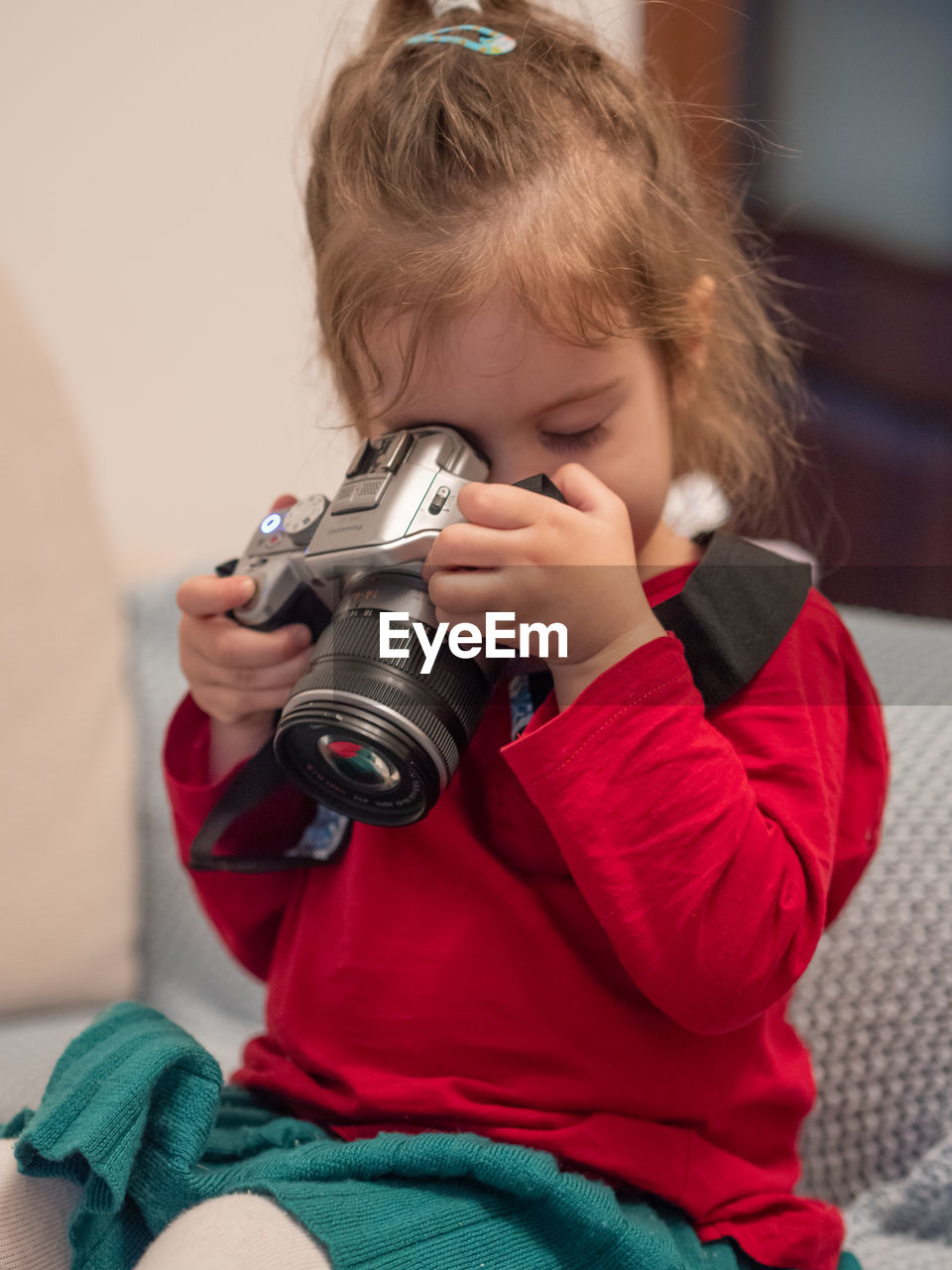 Little girl looking through camera learning photography