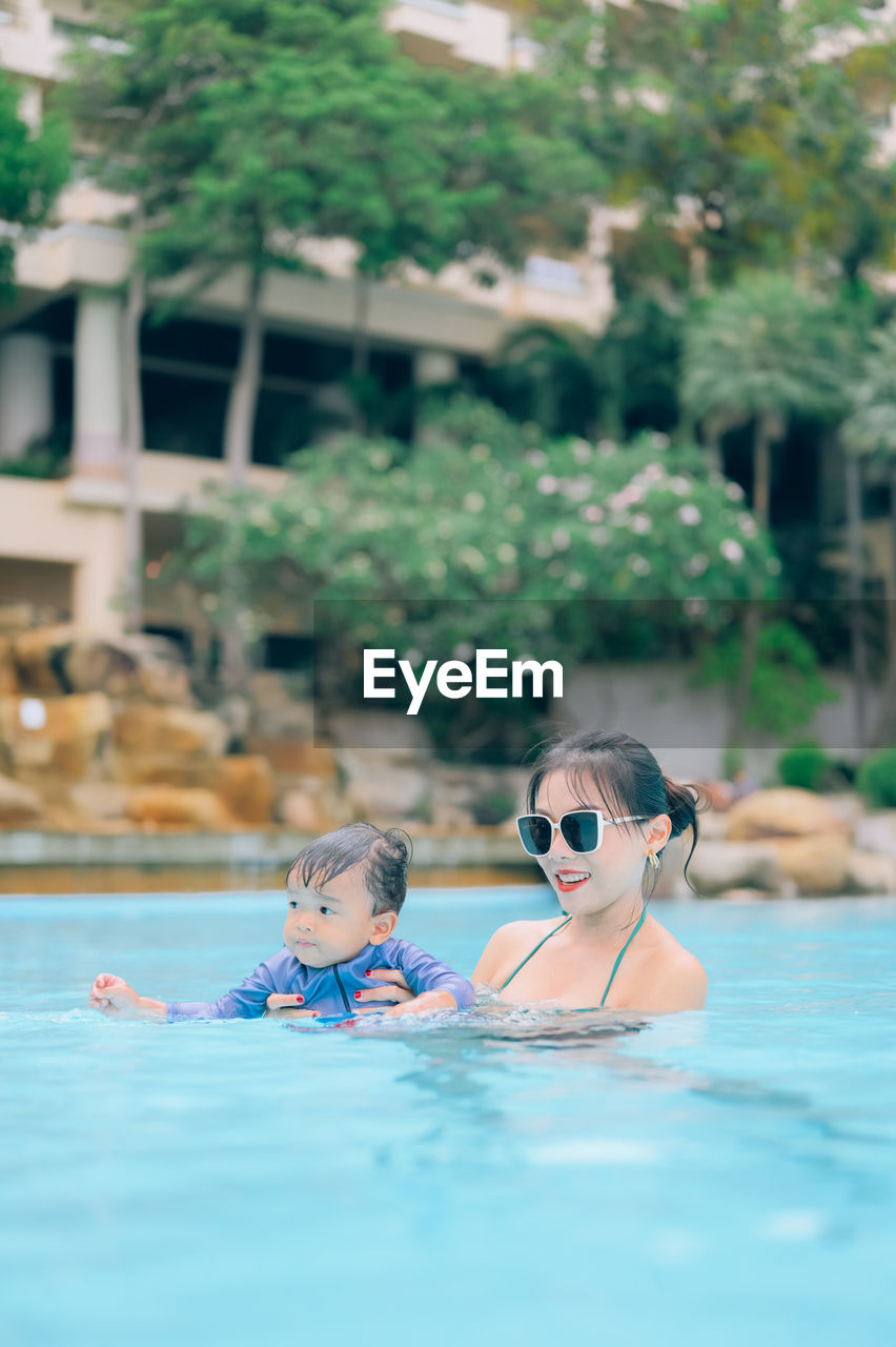 PORTRAIT OF WOMAN SWIMMING IN POOL