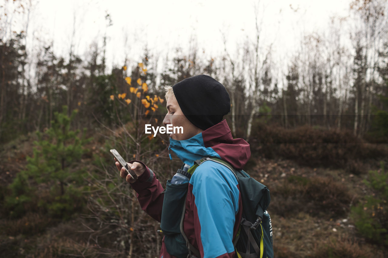 Woman using cell phone in forest