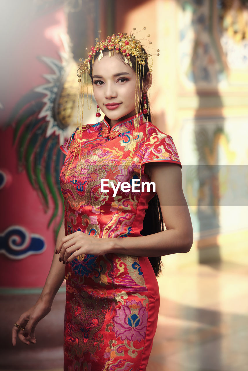 Beautiful asian woman in chinese dress traditional with congratulate gesture in chinese new year