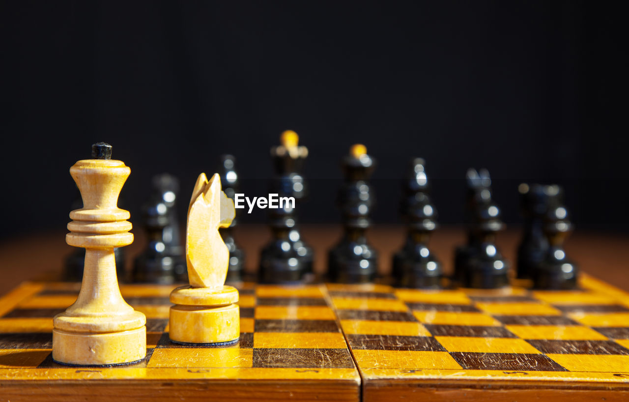 CLOSE-UP OF CHESS PIECES ON BOARD