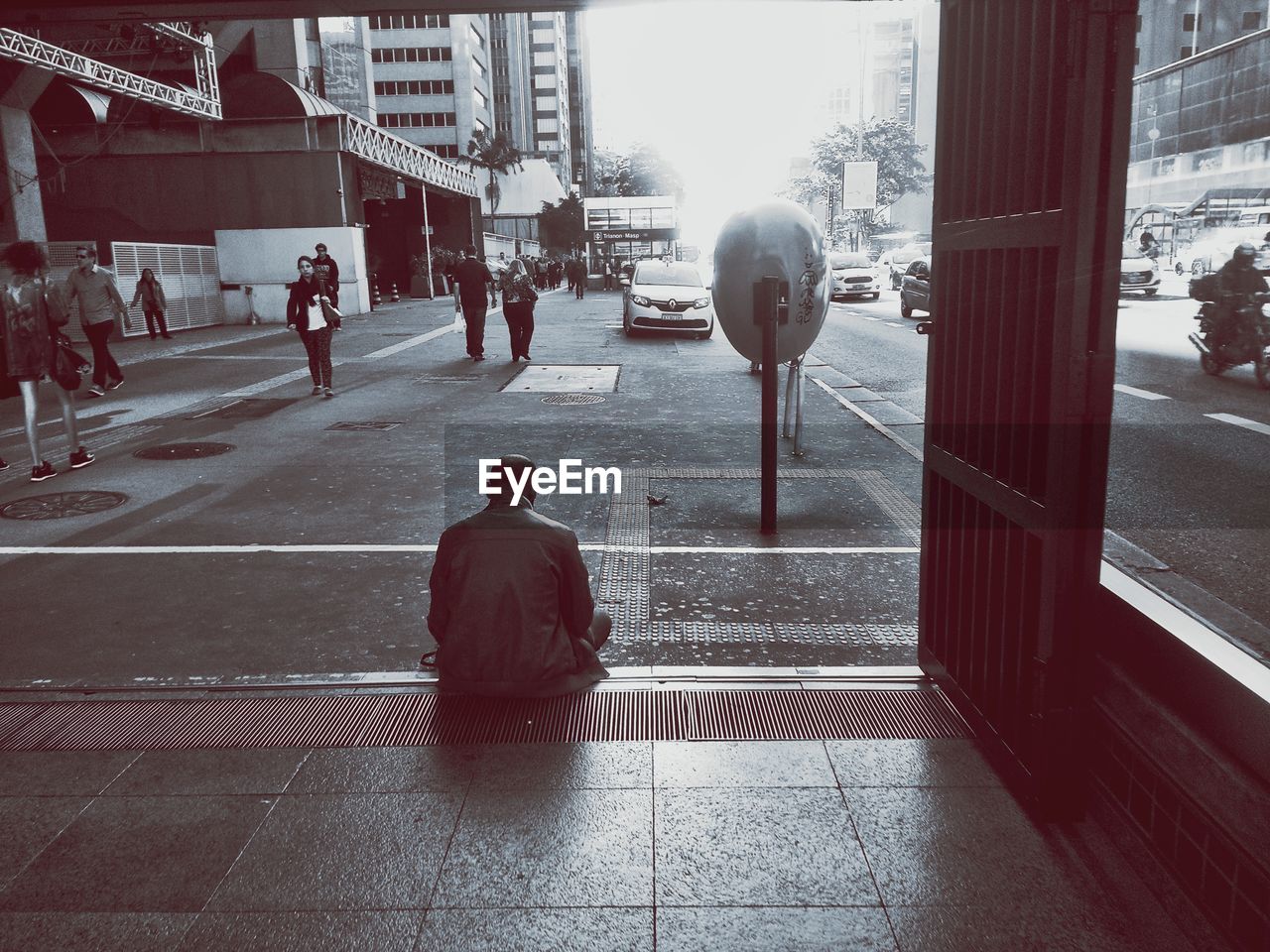 REAR VIEW OF PEOPLE WALKING ON STREET AMIDST BUILDINGS