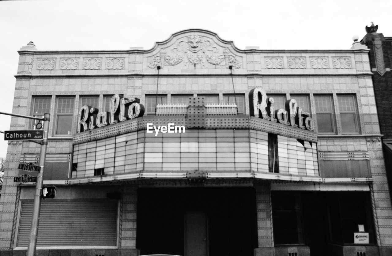 LOW ANGLE VIEW OF TEXT ON BUILDING AGAINST SKY