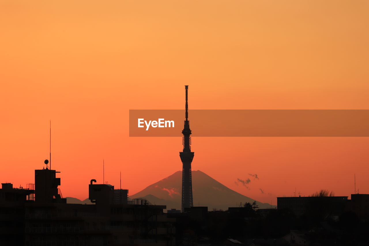 SILHOUETTE BUILDINGS AGAINST ORANGE SKY