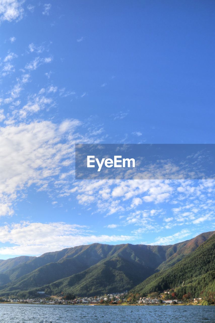 Scenic view of lake and mountains against blue sky