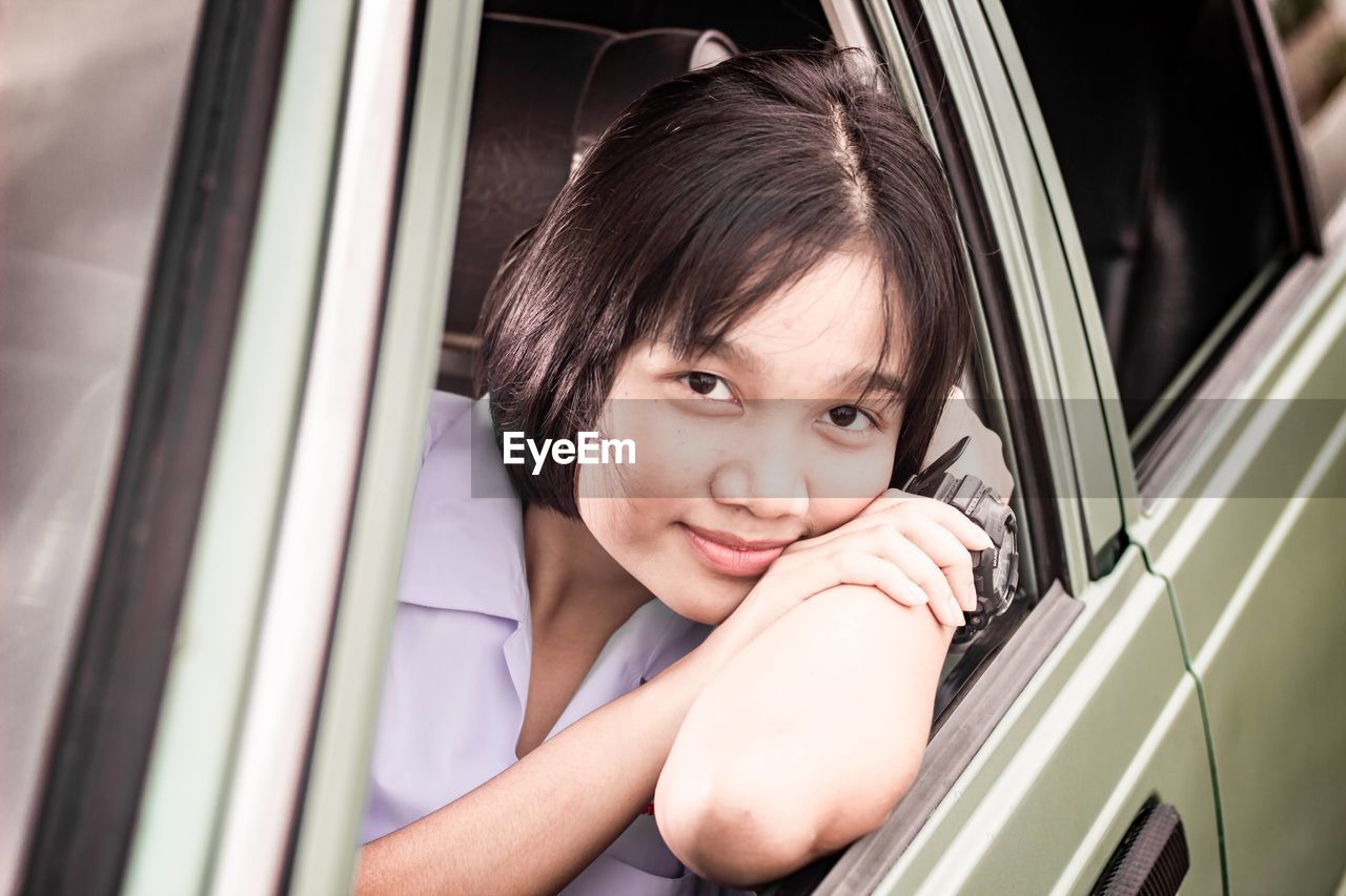 Portrait of pretty woman relaxing and chilling in the classic car.