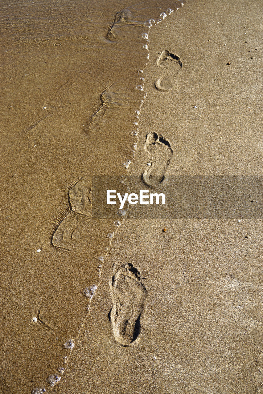 High angle view of footprints on sand at beach