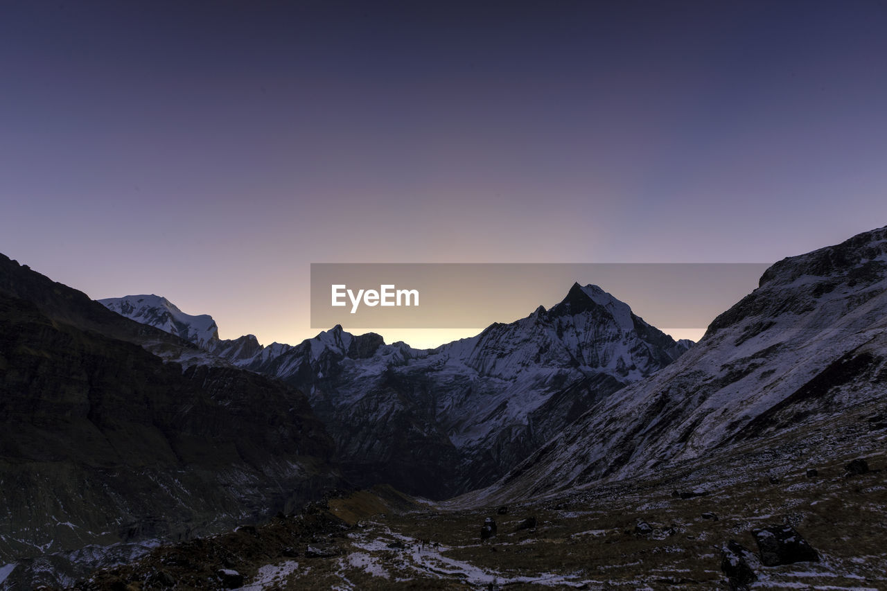 Scenic view of mountains against clear sky during winter