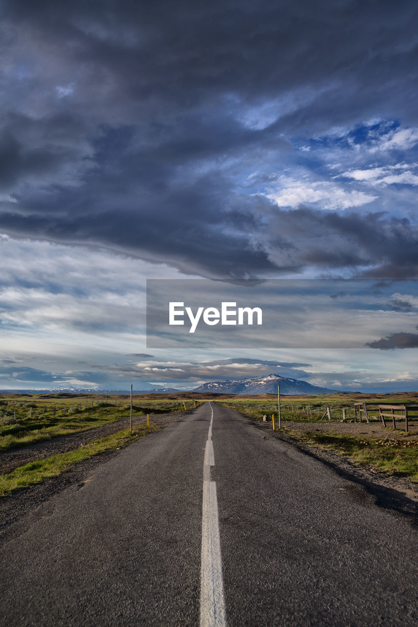 Empty road against cloudy sky