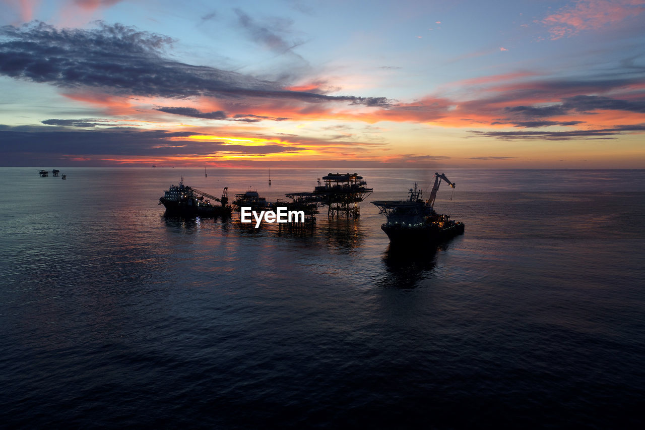 Offshore platform on sea during sunset