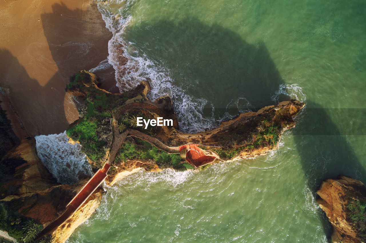 HIGH ANGLE VIEW OF WATER SPLASHING ON ROCKS