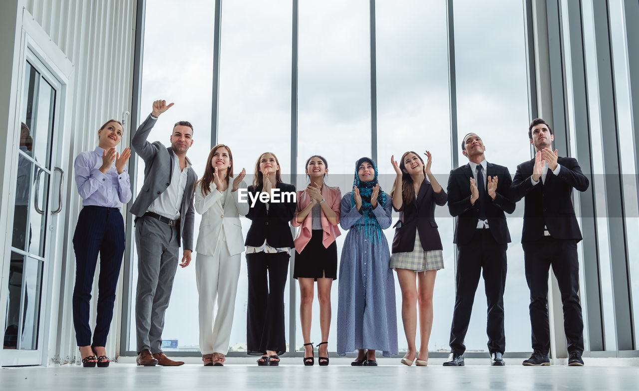 Business people clapping while standing in office