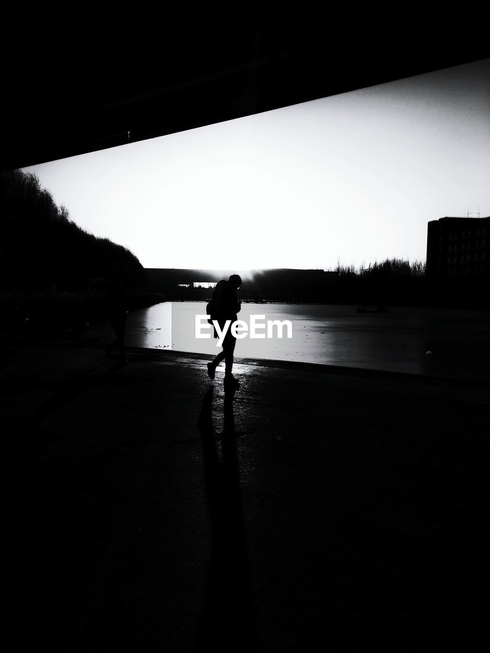 REAR VIEW OF SILHOUETTE MAN STANDING AT LAKE