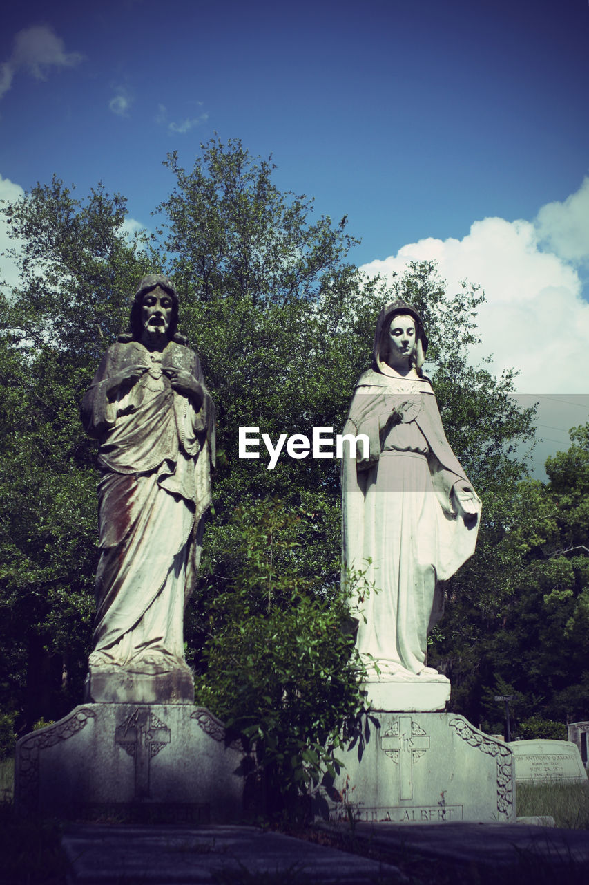 LOW ANGLE VIEW OF STATUE AGAINST TREES AGAINST SKY