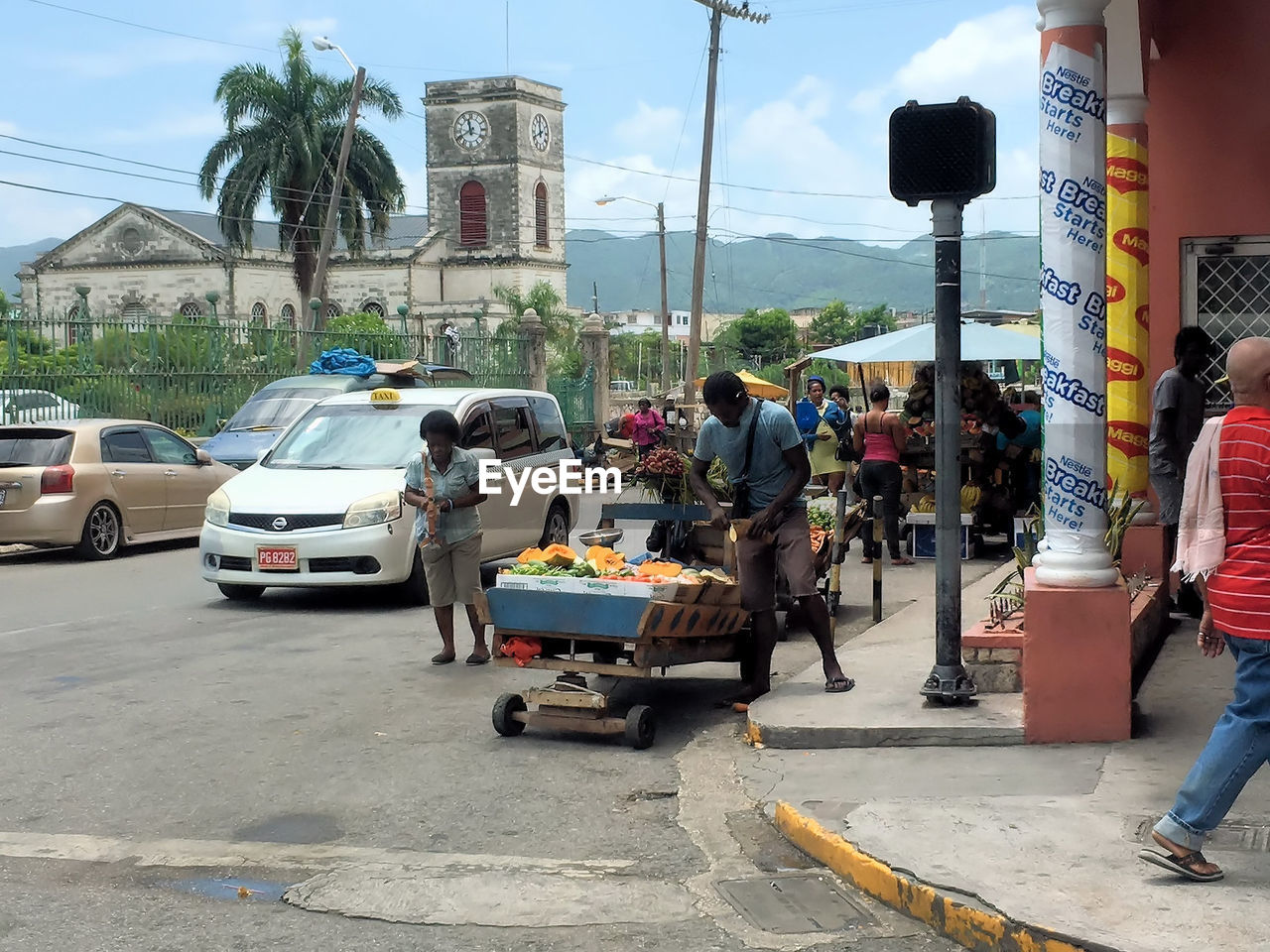 PEOPLE SITTING ON ROAD BY CARS ON STREET