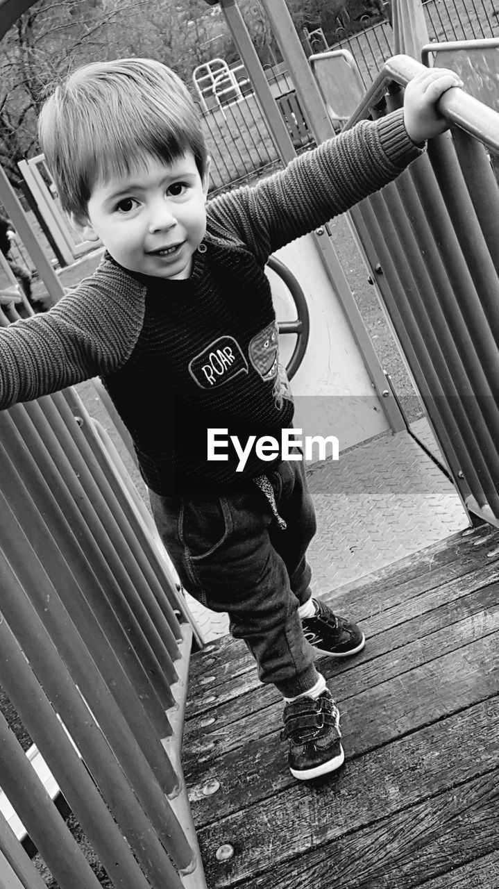 PORTRAIT OF CUTE BOY STANDING ON FLOOR