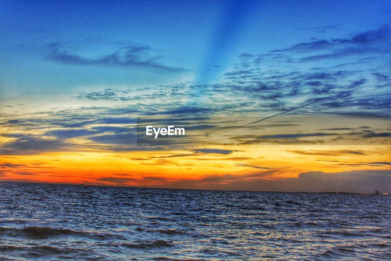 SCENIC VIEW OF CALM SEA AGAINST DRAMATIC SKY