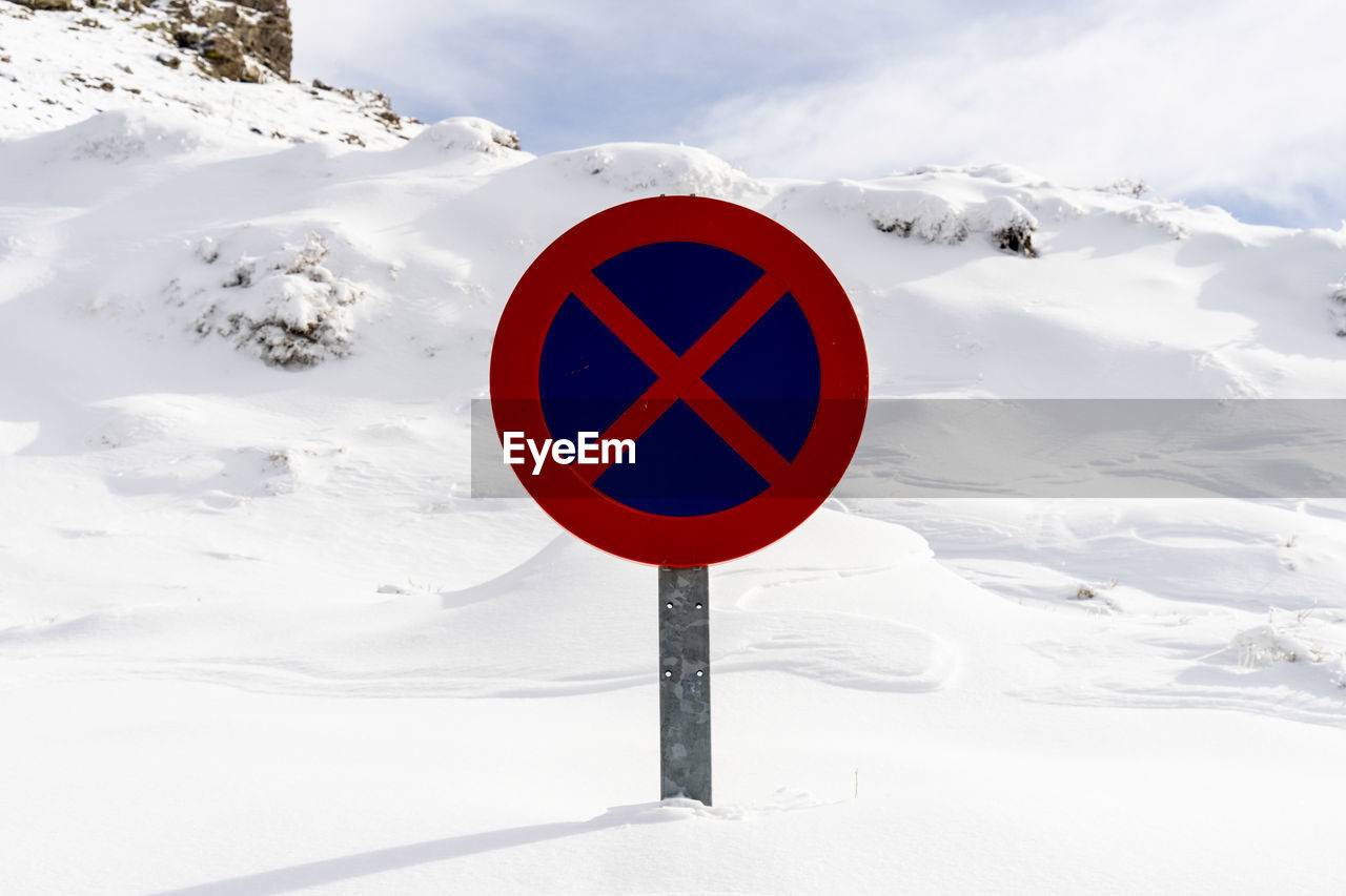 ROAD SIGN ON SNOW COVERED LANDSCAPE