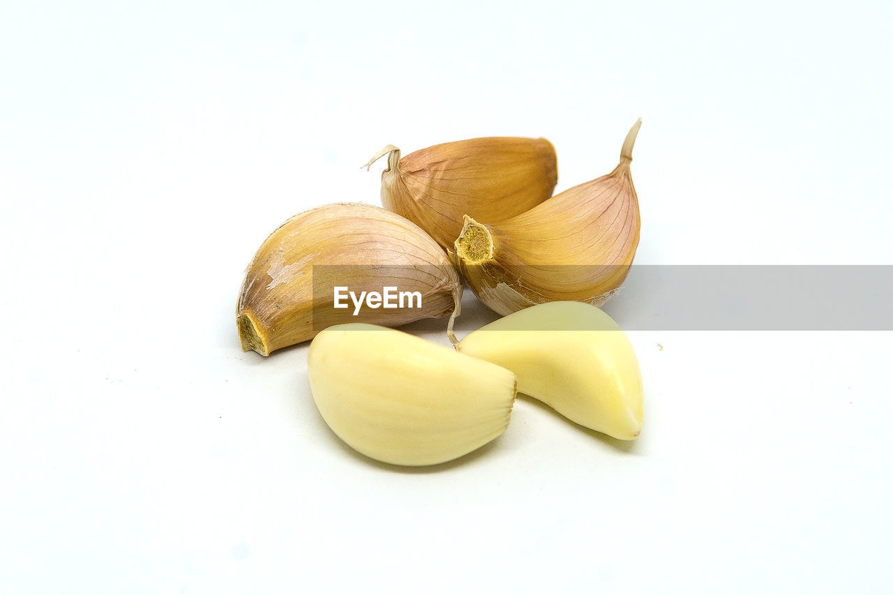 CLOSE-UP OF FRESH YELLOW PEPPER OVER WHITE BACKGROUND