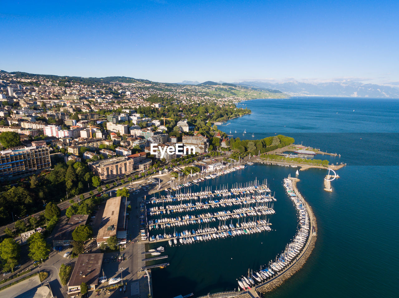 HIGH ANGLE SHOT OF TOWNSCAPE BY SEA AGAINST SKY
