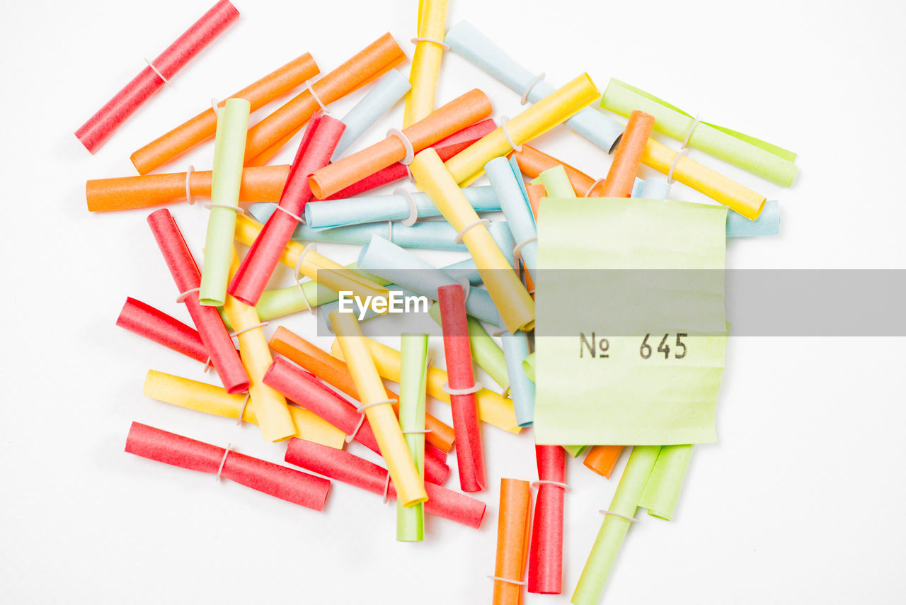 Close-up of multi colored paper rolls against white background