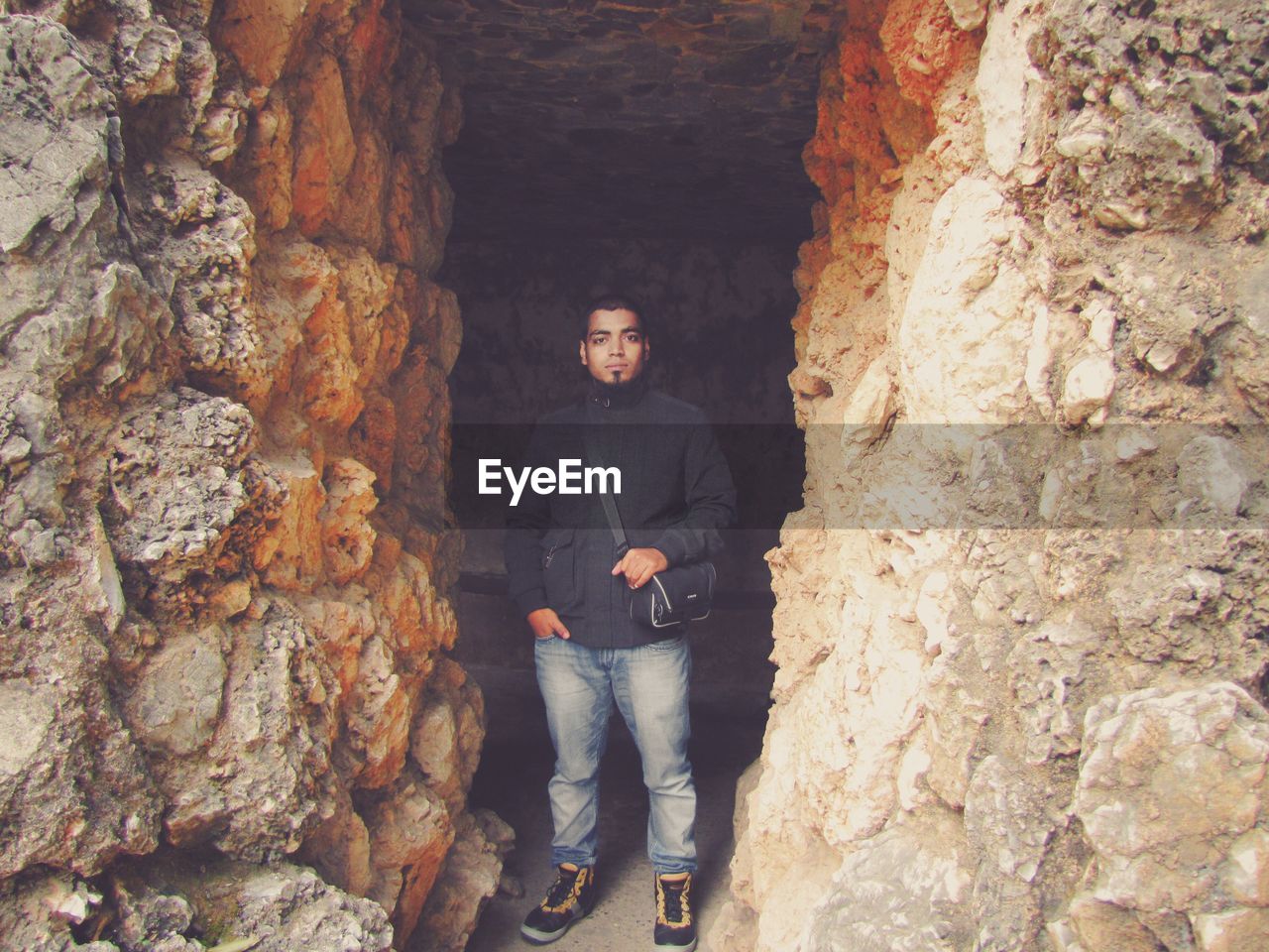 Full length portrait of man standing in cave