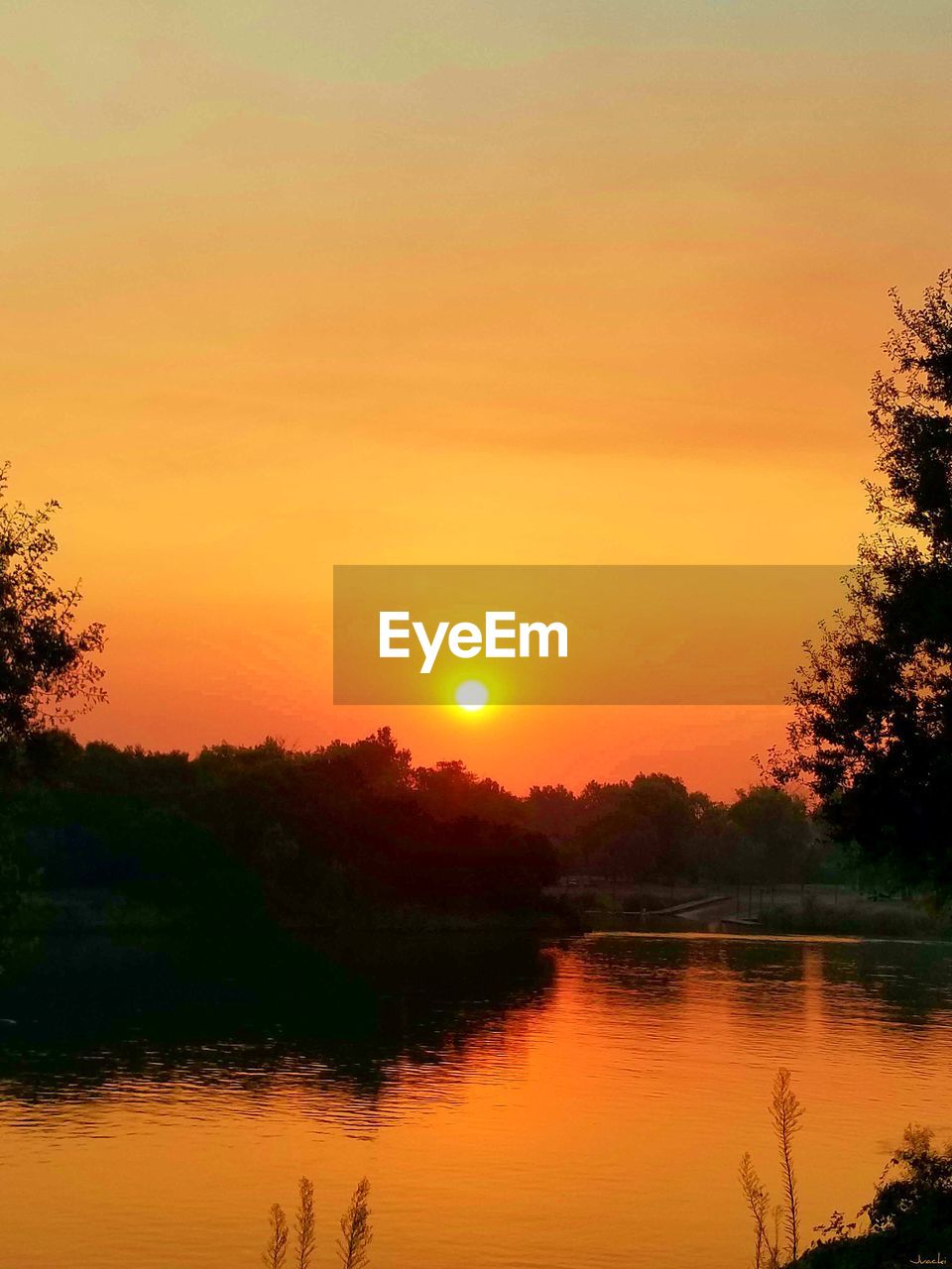 SCENIC VIEW OF LAKE AGAINST SKY AT SUNSET