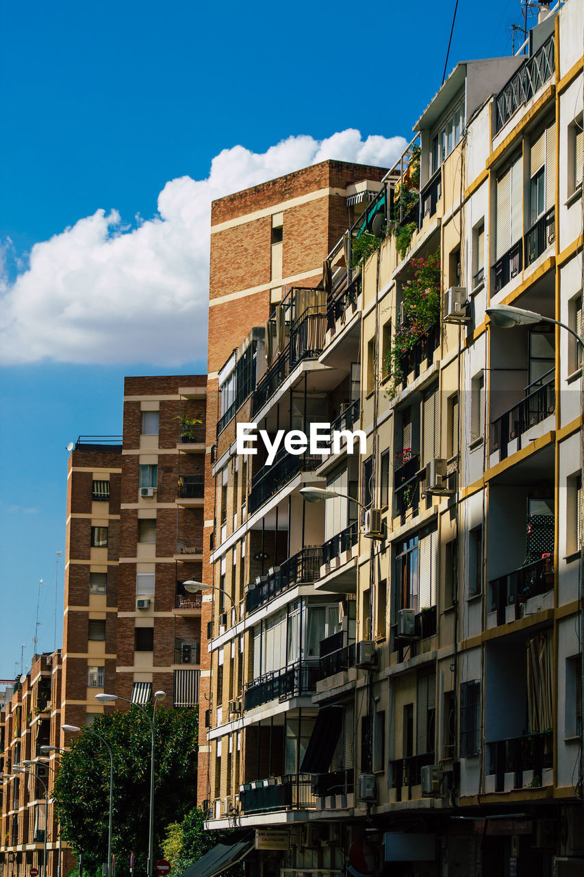 LOW ANGLE VIEW OF RESIDENTIAL BUILDING AGAINST BLUE SKY